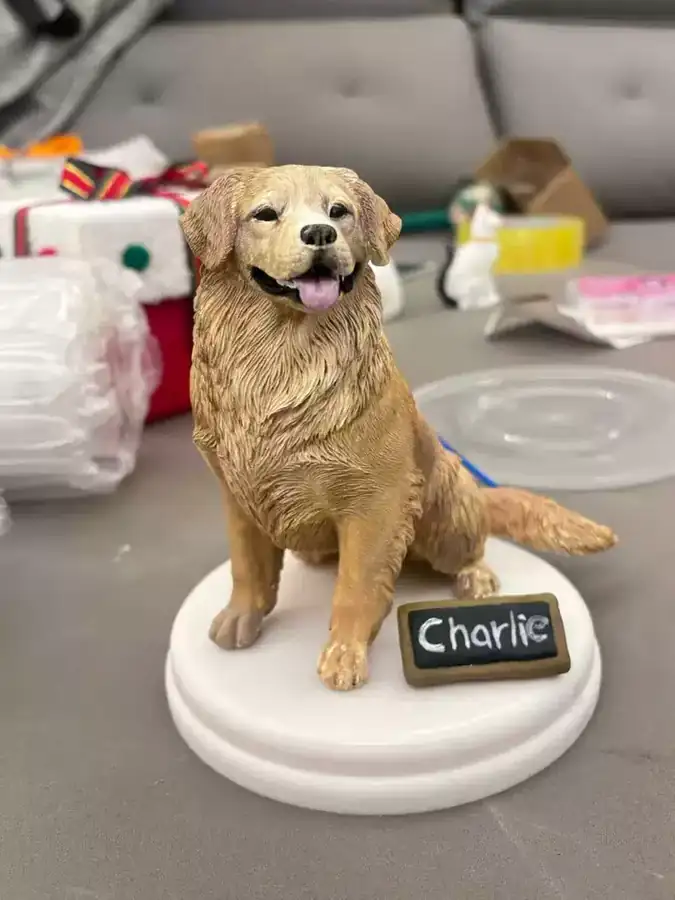 A handmade dog figurine on a white base with a name plaque.